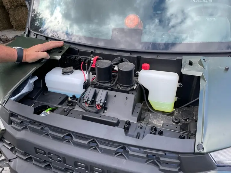 Les deux cylindres noirs situés entre les réservoirs de lave-glace et de liquide de refroidissement assurent l’admission d’air pour le moteur et la ve