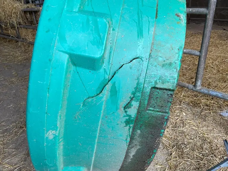 Un bac d'abreuvement percé accidentellement par une fourche de chargeur.