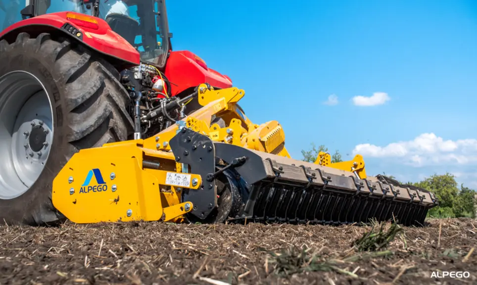 Vue du rouleau de la herse rotative RMT d'Alpego attelée sur un tracteur Case IH Maxxum 120