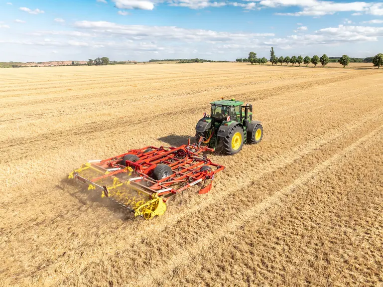 Scalpeur Plano VT 6060 de Pöttinger au travail avec tracteur John Deere