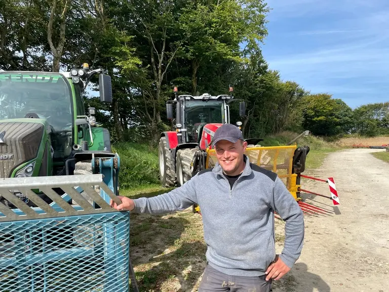 Timothée Dalmont, chauffeur de la Cuma des trois vallées (Manche), devant les tracteurs Fendt 718 Vario et Massey Ferguson MF 8S.225 équipés de fourch
