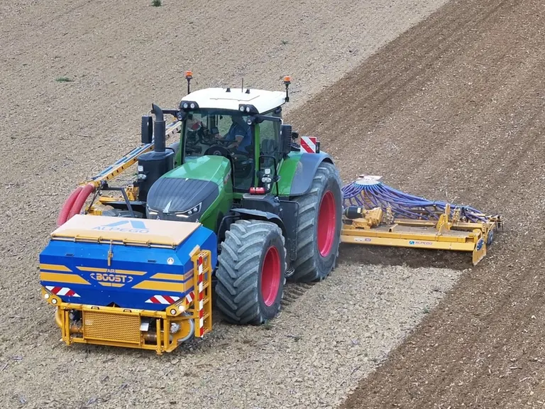 Trémie frontale Alpego Airboost sur tracteur Fendt avec herse rotative Alpego de 8 m et barre de semis