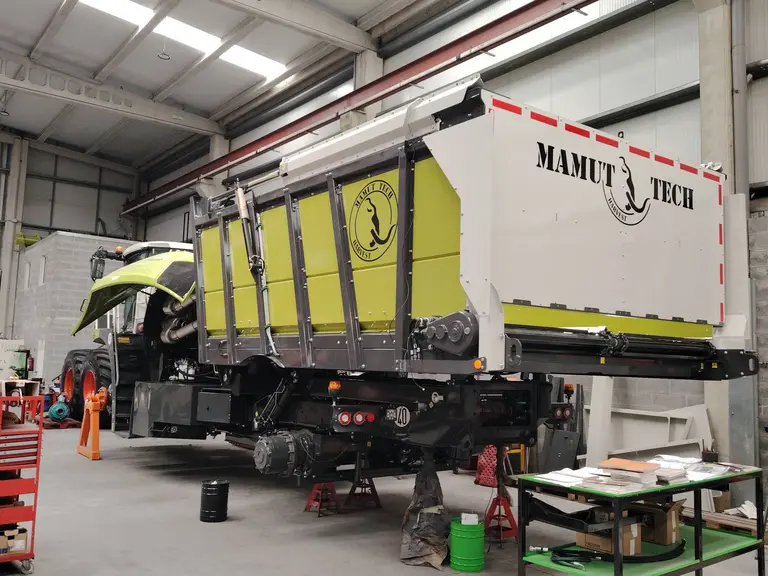 Ensileuse Claas Jaguar articulée à trémie préparée par Mamut-Tech dans un atelier