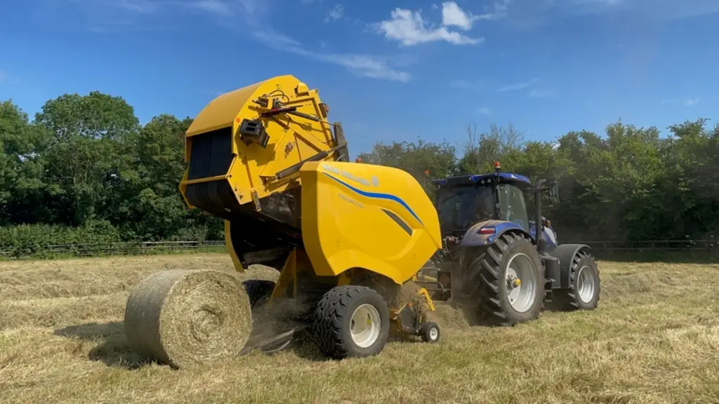 <em class="placeholder">Presse à balles rondes à chambre variable New Holland Pro-Belt 165 au travail dans le foin avec tracteur New Holland T7.210 AutoCommand</em>