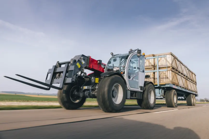 <em class="placeholder">Chargeur télescopique Massey Ferguson tractant sur la route un plateau rempli de pallox </em>