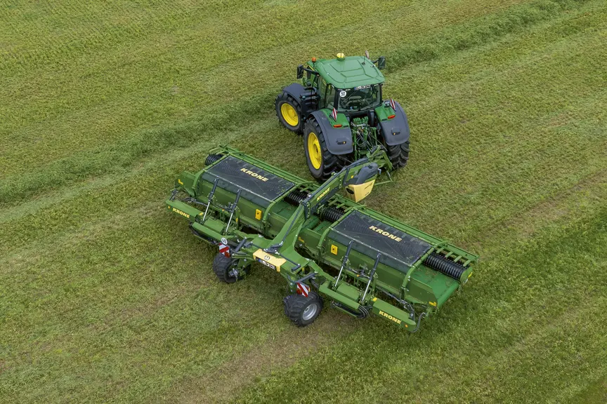 Andaineur à tapis Krone Swativo T 1040 Pro derrière un tracteur John Deere