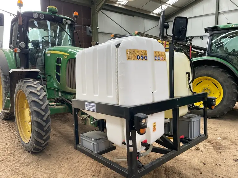 Cuves frontales du pulvérisateur Ara d'Ecorobotix attelé sur un tracteur John Deere 7430