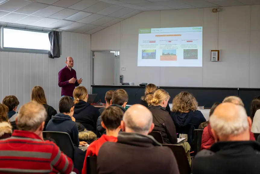 Un groupe d'agriculteurs et de lycéens assistent à une présentation.