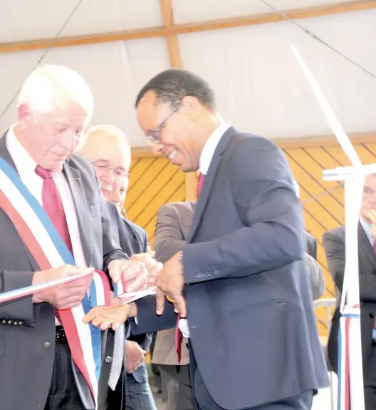 Un symbole : coupage de ruban entre le maire de Saint-Saury (Cantal) et le sous-préfet (lotois), dans une salle polyvalente, les éoliennes de la Luzet