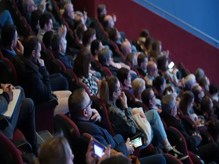 Personnes assises dans la salle de cinéma de Vulcania.