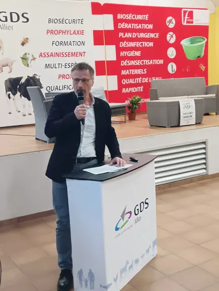 un homme parle au micro derrière un pupitre