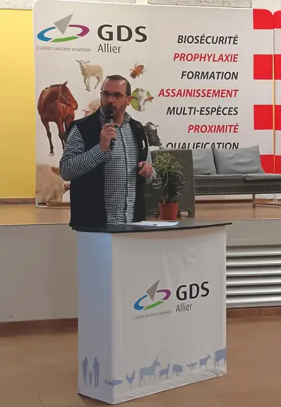 un homme parle au micro derrière un pupitre