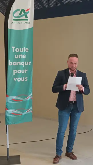 un homme lit une feuille au micro