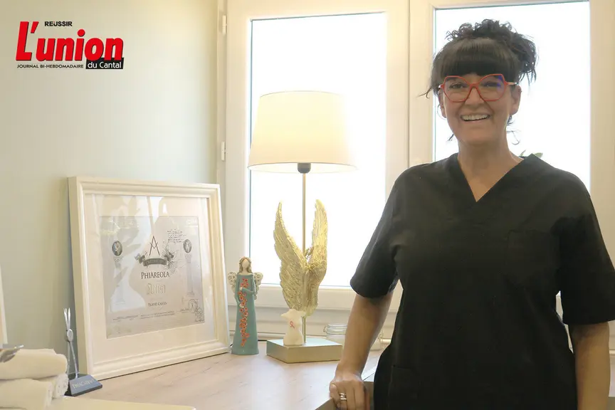 Une femme souriante devant une fenêtre.