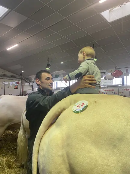 Adrien, sécurisé par son papa Thomas Mortagne, est sur sa vache Ultrabelle - premiers prix de section et d'excellence - achetée le jour de sa naissanc