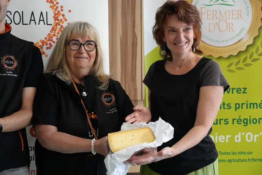 Véronique Sauzèdde, vice-présidente Solaal Auvergne-Rhône Alpes, à gauche donnant symboliquement une tomme de vachet à Isabelle Salles, coordinatrice