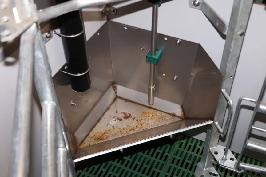 Un capteur en fond d'auge permet de gérer les distributions d'aliments et d'eau. Une petite trappe actionnée depuis le couloir permet une vidange de l