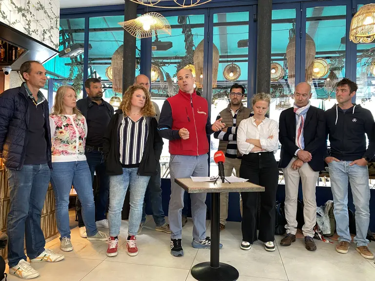 Groupe de 10 agriculteurs s'exprimant dans un bar à Paris devant la presse