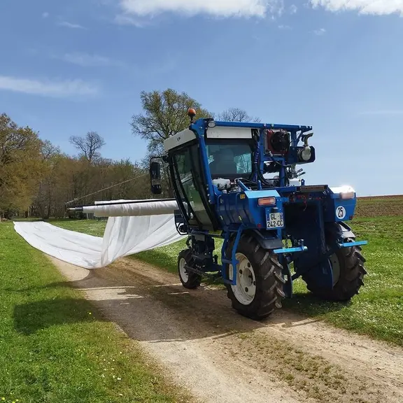 La machine autoconstruite par le Château de Cruzeau, dans le Bordelais, s'installe à l'arrière de l'enjambeur pour déployer les bâches, mais à l'avant pour les ôter.