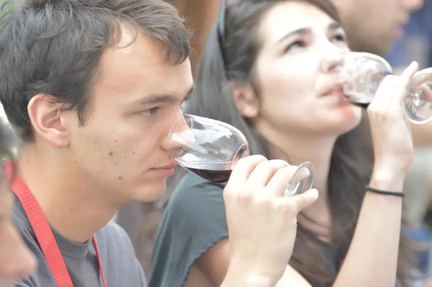 Jeune homme et jeune femme  en dégustation de vin rouge à Bordeaux fête le vin. Appréciation des arômes. Odorat. Nez. Saveur. Consommation de vin.  Ve