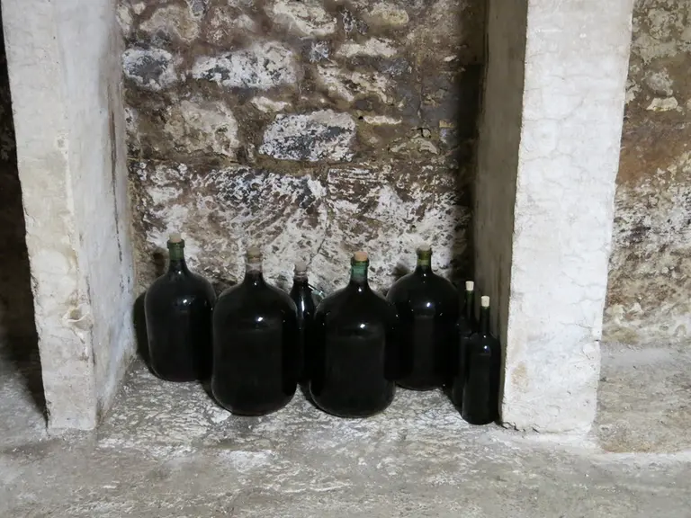 La cave en pierre abrite des dames-jeannes contenant la première cuvée de malbec Cédric Genieys.