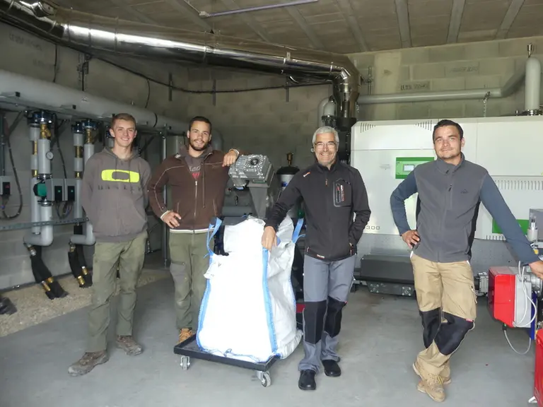 L'équipe des trois exploitants dans le local de la chaudière à bois de 300 kW. De gauche à droite : David (salarié agricole), Maxime, Franck et Cyril