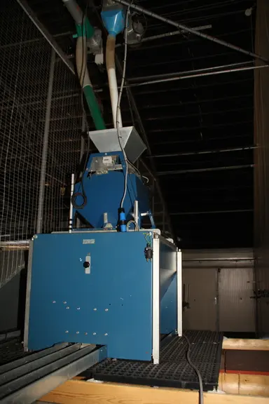 L'aliment provenant d'un des deux silos transite par une bascule au-dessus de la trémie (distribution quantitative). © A. Puybasset