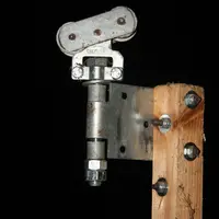 Le support est fixé sur un liteau carré de 35 cm en bois dont la longueur a été établie en fonction de la hauteur des portes de la stabulation et de l