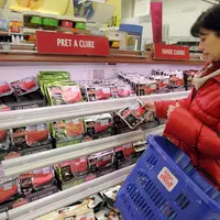 Cliente en grande distribution achetant des pavés de boeuf au rayon viande d'un supermarché. Magasin Carrefour. Produit alimentaire issu de la product