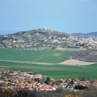 villages du Puy-de-Dôme. paysage de village rural en hauteur. parcelles agricoles traverseés par une route.