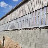 Les plaques de polycarbonate amovibles sont montées sur des rails de portes coulissantes. Un "U" en fer à l'envers sert de guide en haut.