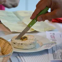 Fromage en train d'être coupé lors du Concours Saveurs Nouvelle-Aquitaine des fromages de chèvre fermiers et artisanaux