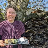 Une femme tient un plateau de fromage.