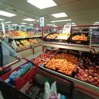 femme faisant ses courses et passant devant la gondole d'abricots et de pêches et nectarines en promotion. Carrefour Market Paris 12e jeudi 15 juin 20