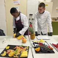 Wassim de Wasko'Fruits découpe un pomelo sous l'oeil attentif de Cristin Ambros, Meilleur apprenti primeur de France le 15 novembre 2023.