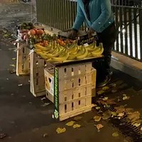 Etal fait de cagettes d'un vendeur à la sauvette de fruits et légumes à la sortie d'une bouche de métro à Paris.