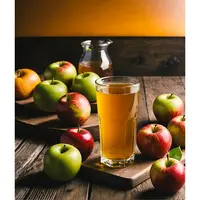 des pommes autour d'un verre de jus de pomme