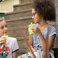 deux enfants qui consomment des compotes de fruits en gourde