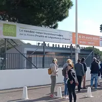 Des personnes font la queue pour pouvoir rentrer sur un salon professionel.