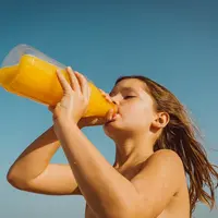 Enfant buvant une bouteille de jus de fruits