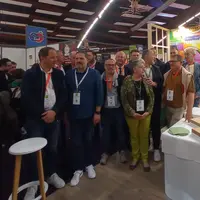 groupe de personnes qui posent sur un stand sur un salon