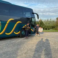Un bus déposant des saisonniers agricoles dans un verger de pommiers, en région Nouvelle-Aquitaine.
