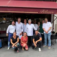 Des membres de la filières mirabelle de lorraine posant devant un restaurant à Paris.