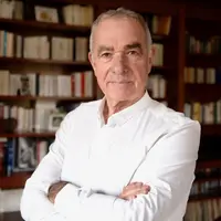 Daniel Sauvaitre, président d'Interfel, posant decant une bibliothèque remplie de livre.