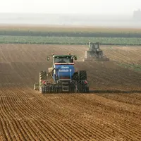 Semis de blé. Chantier agricole. tracteur et semoir. outil de travail du sol. préparation du lit de semence. semences. brume à l'horizon.