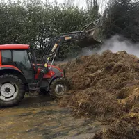 Tracteur devant un tas de fumier