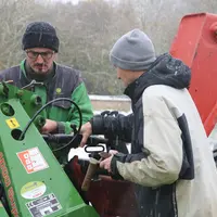 Exploitant agricole et son salarié dans la cour de ferme sous la neige en novembre 2024