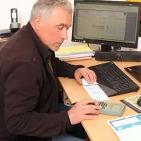 Vigneron controlant sa tresorerie en especes et effectuant un paiement par cheque.