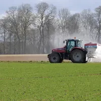 Tracteur épandant de l'azote dans une parcelle de blé.