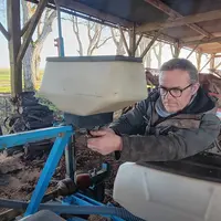 Emmanuel Puaud, agriculteur à Rom (79) travaillant sur la trémie d'un semoir